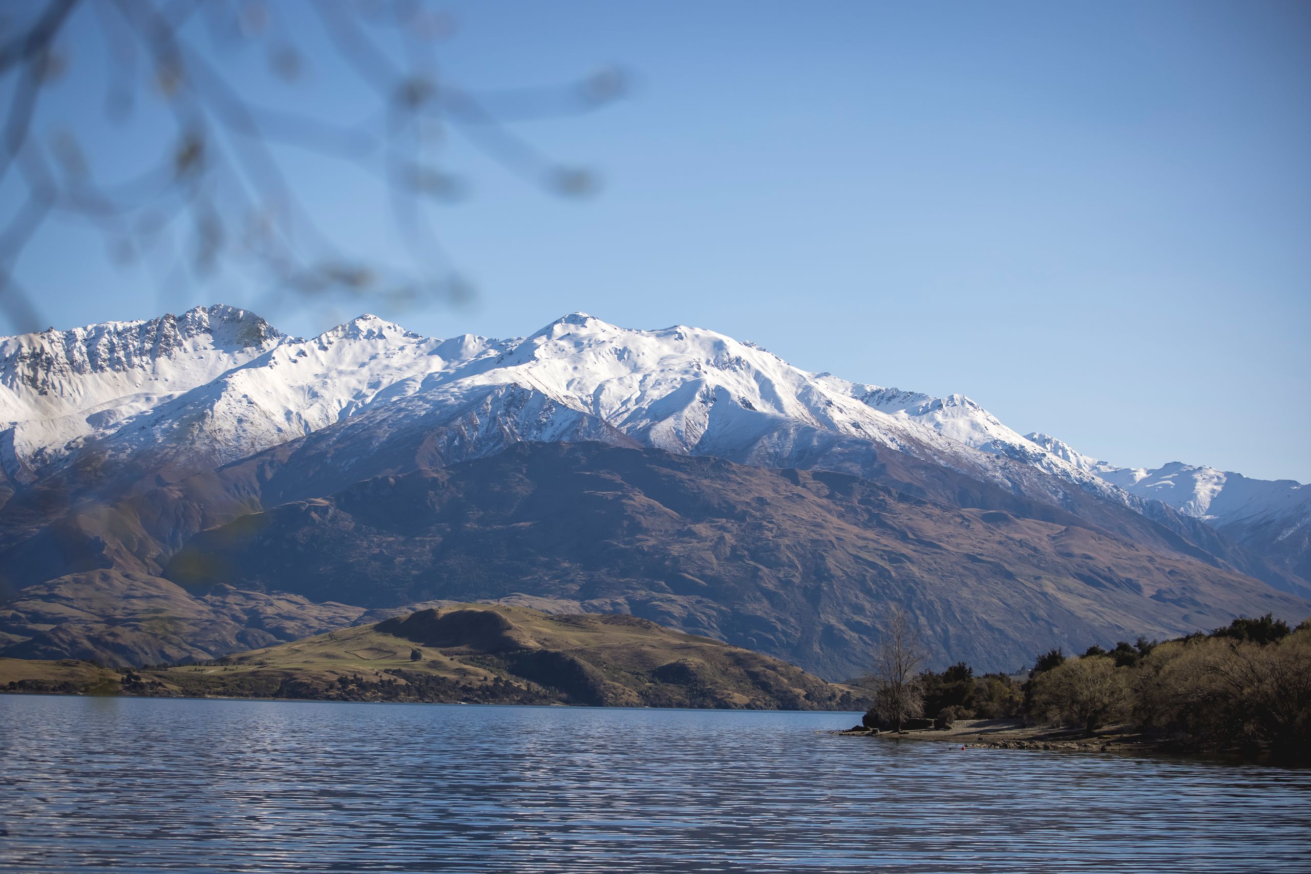 Mountains covered in snow in Queenstown overlooking a lake